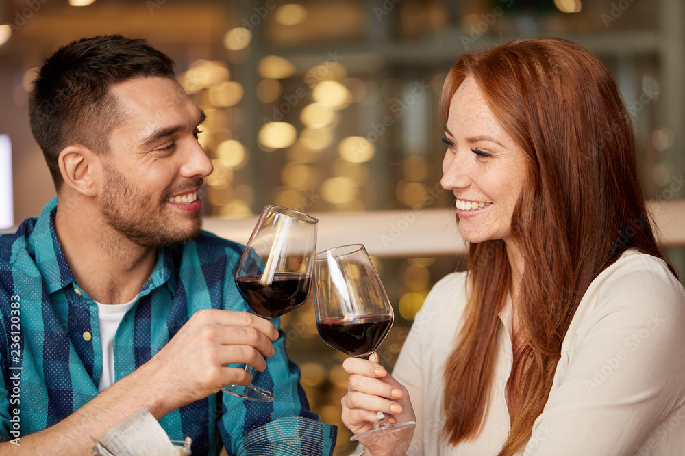 celebration, holidays and people concept - happy couple drinking red wine at restaurant celebration, holidays and people concept - happy couple drinking red wine at restaurant