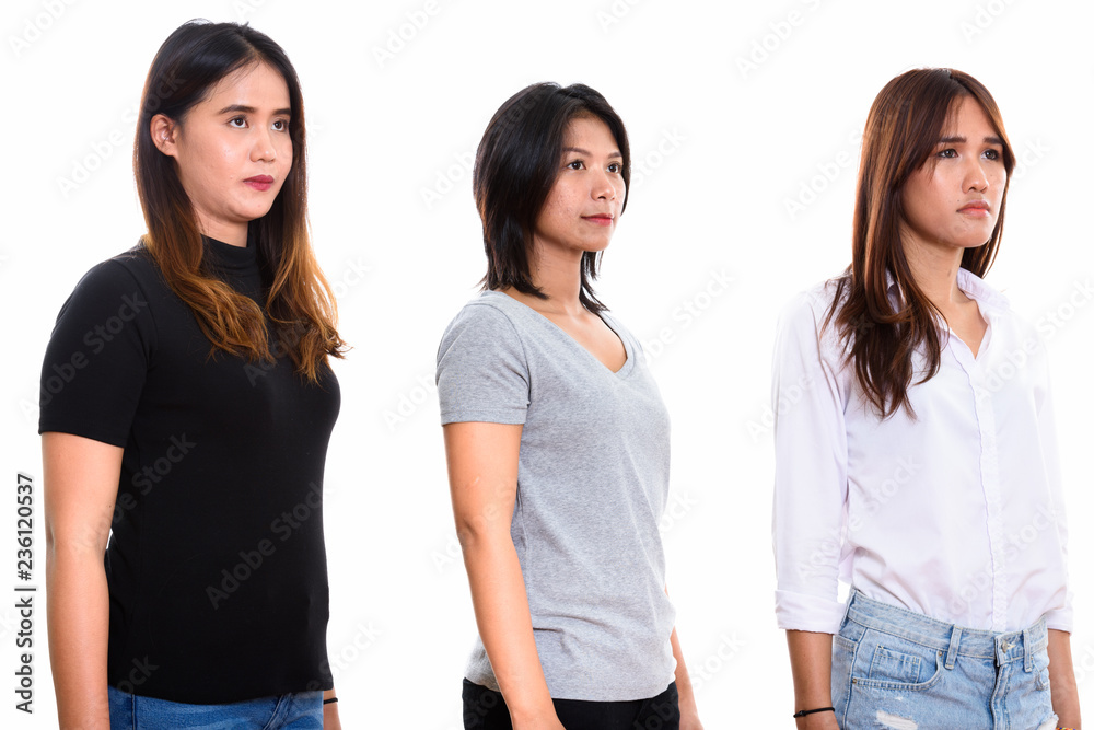 Studio shot of three young Asian woman friends thinking Studio shot of three young Asian woman friends thinking