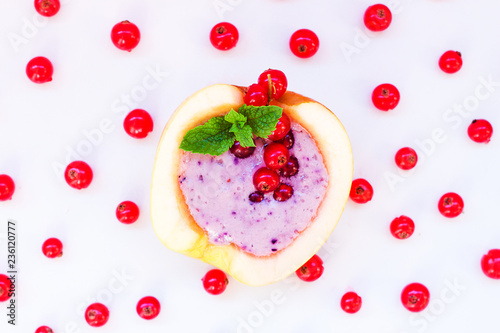 Smoothie in apple with blueberry  banana  mint  red currant and milk on white background. Flat lay. Minimal and modern summer concept.