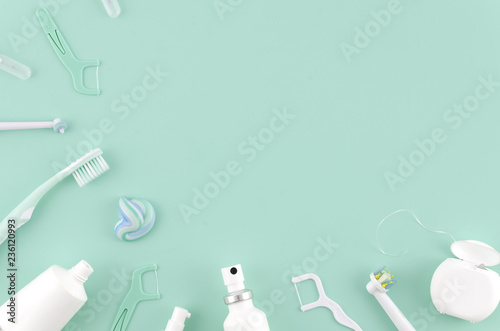 Flat lay composition with manual toothbrushes and oral hygiene products on mint background Stomatologist mock up copy space. Teeth care Frame concept photo