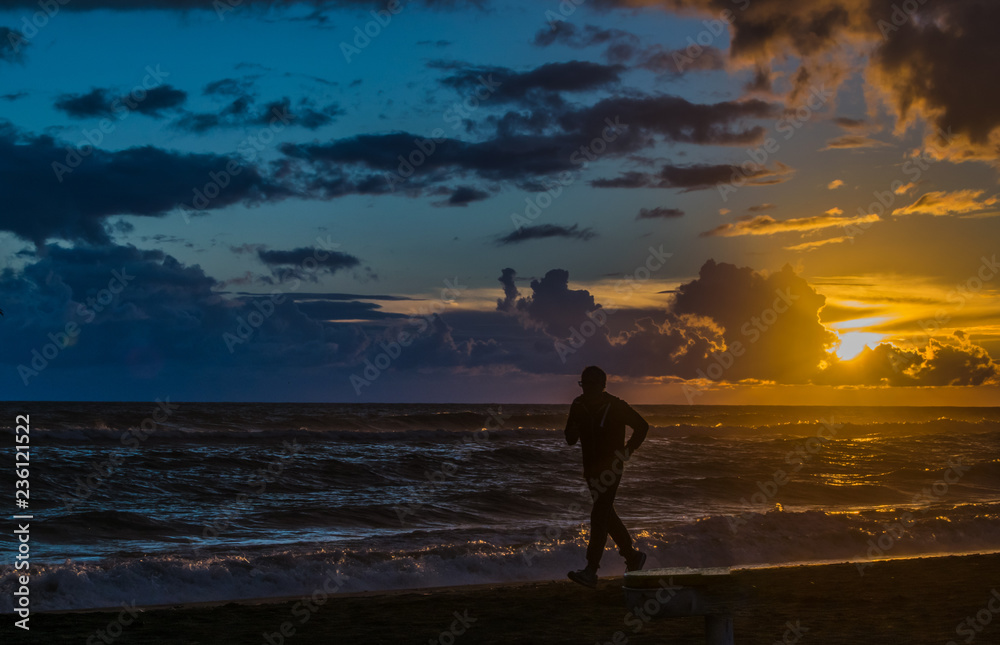 Fototapeta premium Man running on the beach at sunset