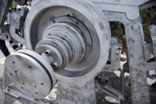 Beautiful matte silver metal industrial machinery steel cogs in a rustic industrial factory setting. Well used processing machinery parts.