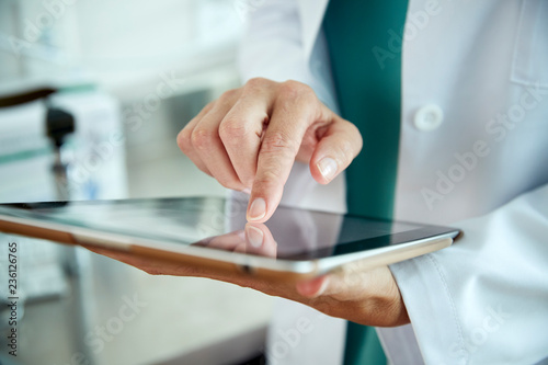 Fototapeta Doctor touching a tablet