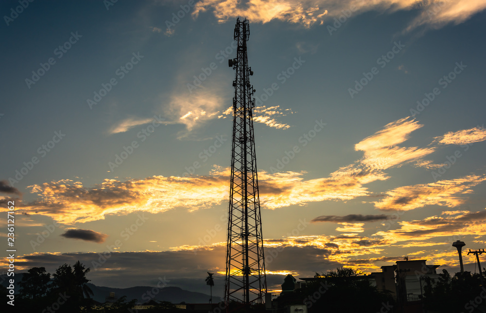 Telecommunication cellular tower in sunset sky.