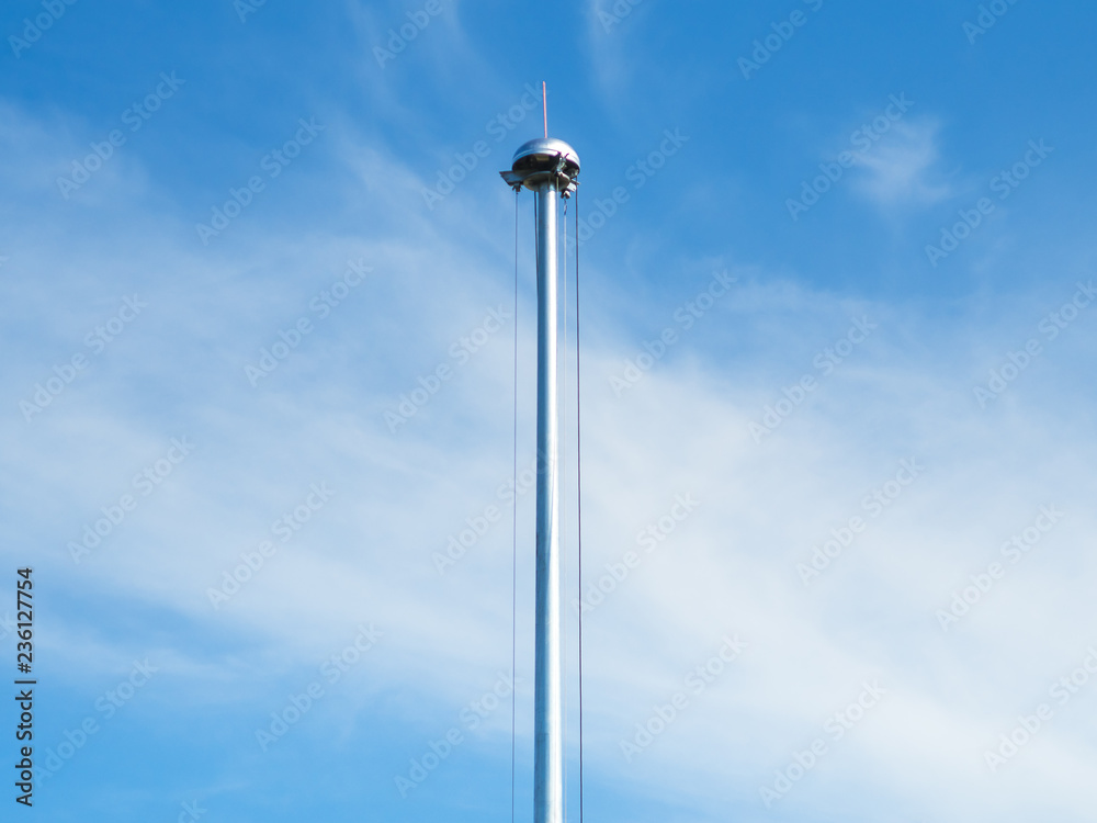 Repair the pillars spotlights with blue sky view. Sport light pole drop with sling for repairing and maintenance on the ground. - selective focus.