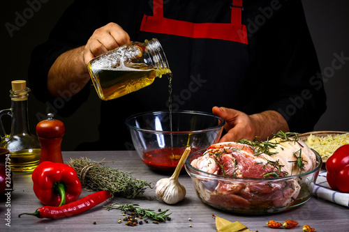 chef hands preparing pork knuckle. Cook preparing delicious pork knuckle with the addition of beer. Bavarian cooking recipe