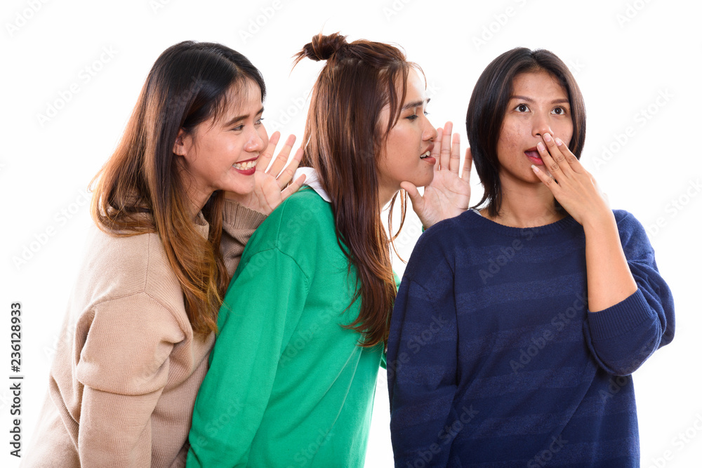 Studio shot of young Asian woman looking shocked with both frien Studio shot of young Asian woman looking shocked with both frien