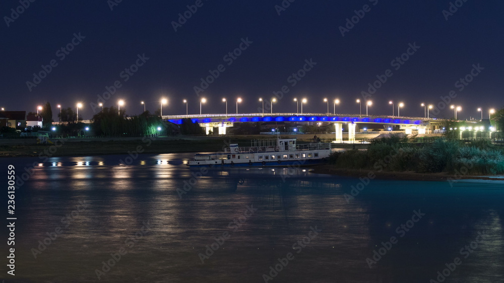 Ship and illuminated bridge on the riverside Ural in city Atyrau timelapse hyperlapse