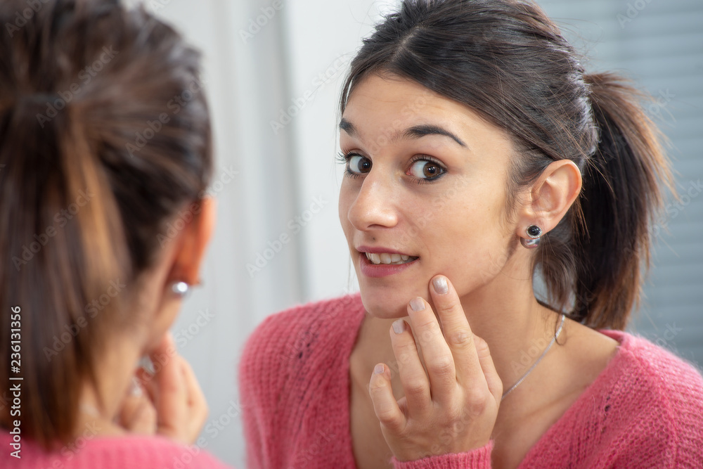 young brunette woman puting makeup in the mirror young brunette woman puting makeup in the mirror