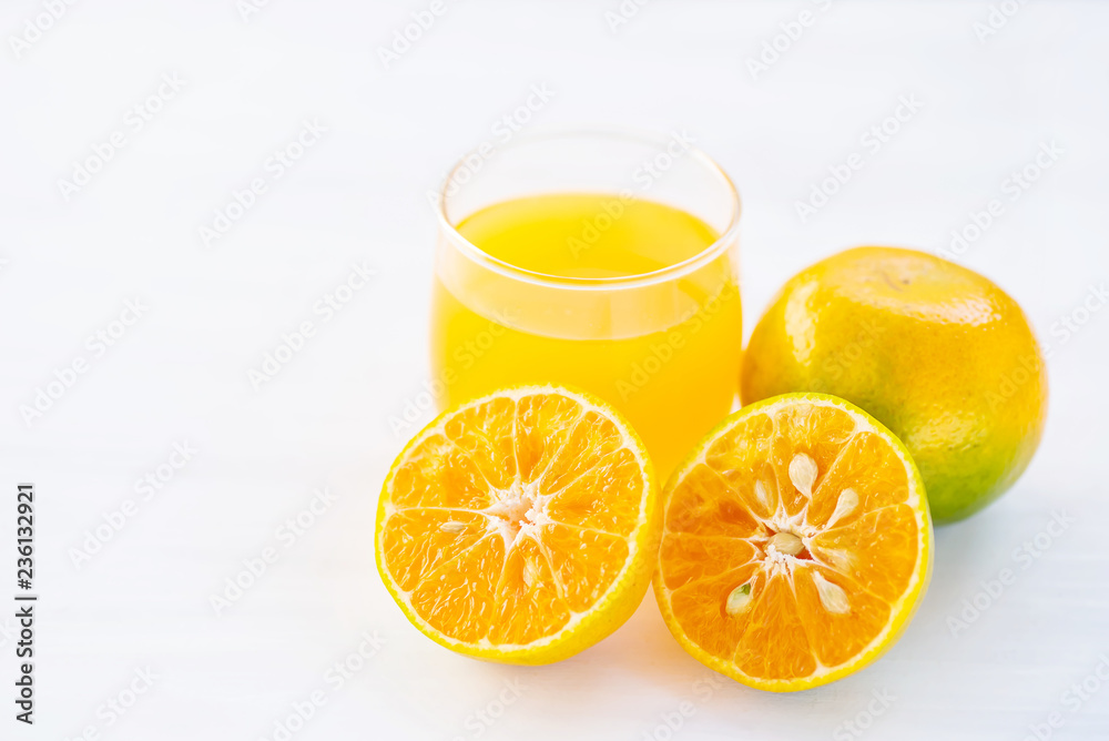 Sliced tangerine orange fruit and juice on white table Sliced tangerine orange fruit and juice on white table
