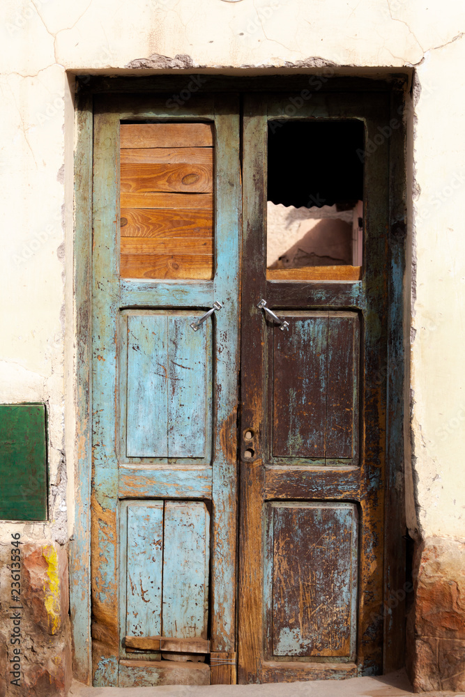 Photo closeup of old aged building made of stone masonry with aged dry wooden door vertical picture
