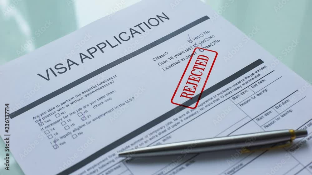 Visa application document rejected, hand stamping seal on official paper closeup