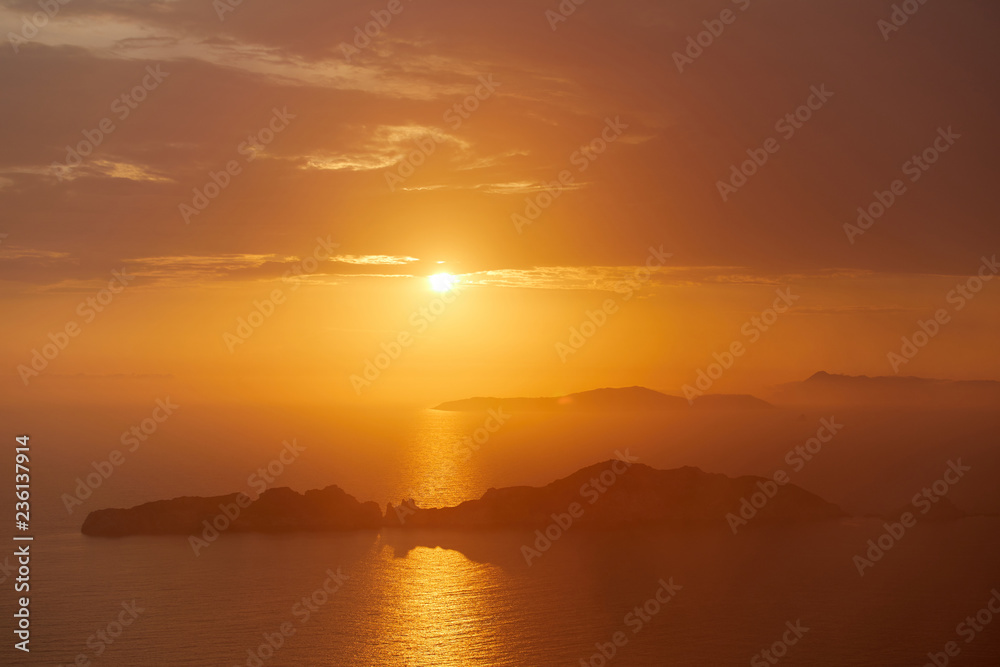 Sunset over the sea. Bright colorful background with sun, sea and rocks