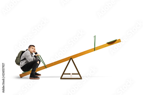 Canvas-taulu Bored teenage schoolboy sitting alone on a see-saw