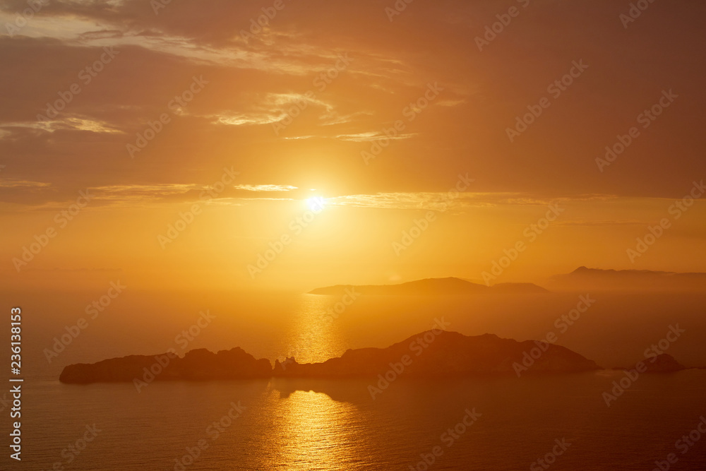 Sunset over the sea. Bright colorful background with sun, sea and rocks