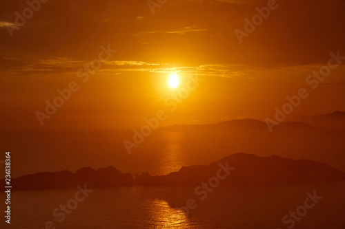 Sunset over the sea. Bright colorful background with sun  sea and rocks