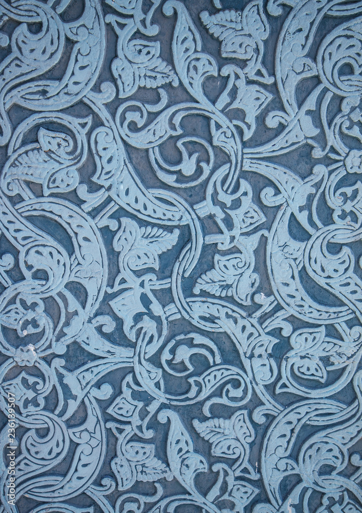 Bas-relief on the building in Oriental style. White ornament on a blue background.