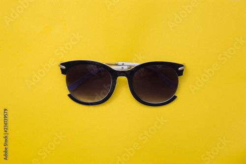 Sunglasses for women in the center on a yellow background. Rectangular summer texture.
