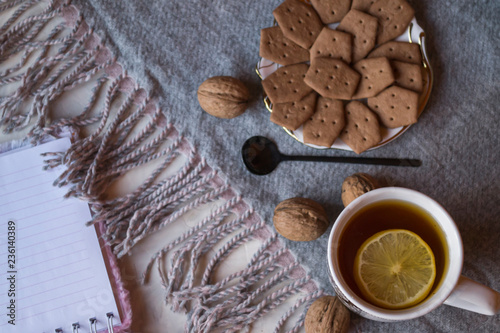 A cup of tea with lemon and cakes. Hygge flat lay.