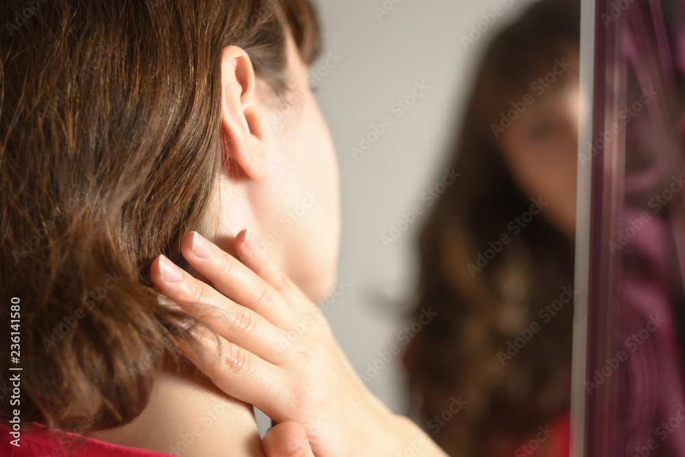 Fototapeta premium Woman applying cream on her neck. Concept of skincare or healthcare