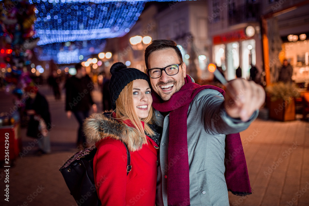 Cute couple at city street on Christmas holiday.