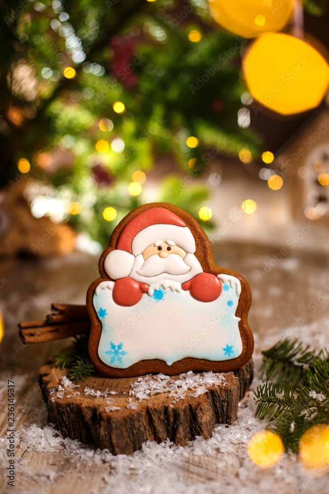 Holiday traditional food bakery. Gingerbread santa claus with copy space in cozy warm decoration with garland lights