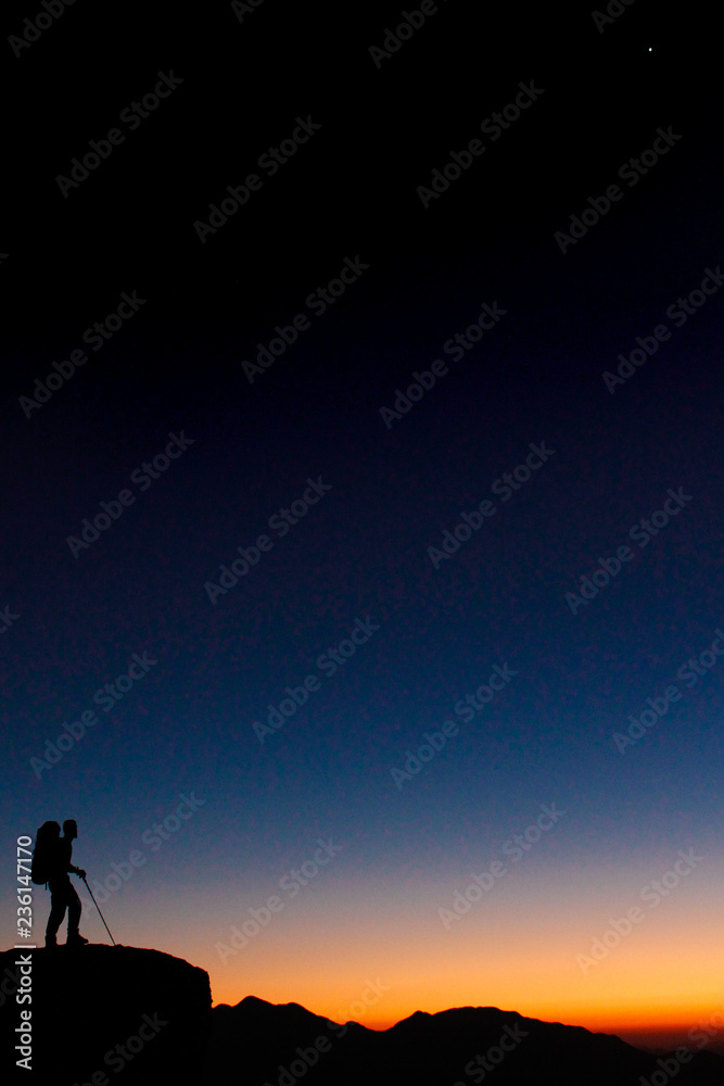 silhouette of man on top of mountain