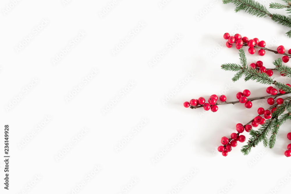Christmas elegant modern composition. Border made of green fir tree branches and red natural berries on white background. Christmas, New Year, winter concept. Flat lay, top view, copy space