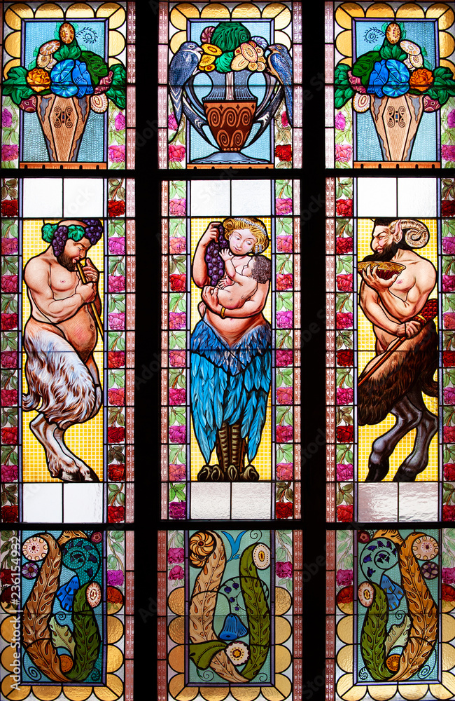 Colorful stained glass window with bowls and fauns. 