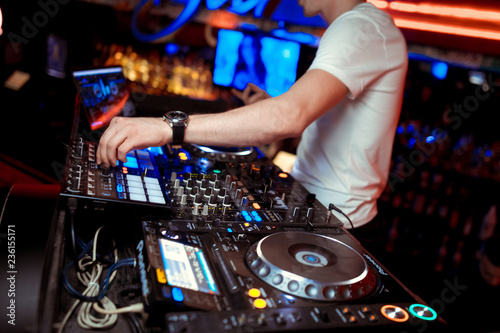 DJ mixer on the table background the night club and dancing people