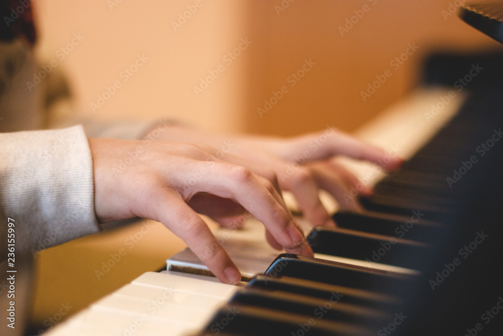 children's hands on the piano keys, rehearsal music, learning to play the piano