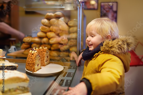 Little boy is looking at Christmas sweets in a German bakery