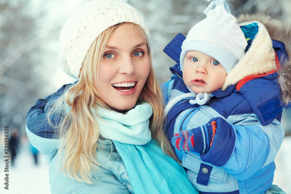 happy mother and baby in winter park. family outdoors happy mother and baby in winter park. family outdoors
