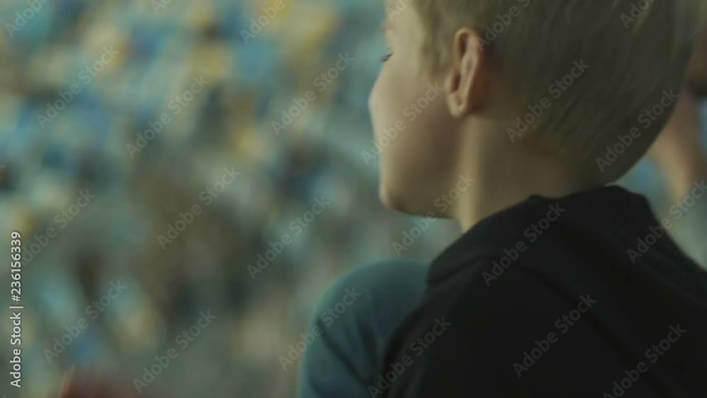 Two brothers nervously watching football game on stadium, championship, close up Two brothers nervously watching football game on stadium, championship, close up