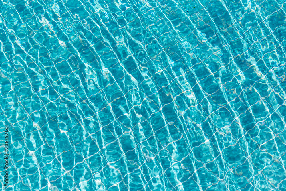 Background of rippled pattern of clean water in a blue swimming pool.