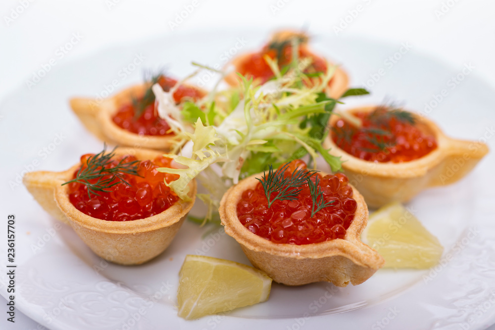 Tartlets with red caviar on a plate. Selective focus. Serve red caviar
Tartlets with red caviar on a plate. Selective focus. Serve red caviar
