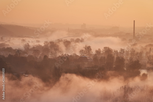 Foggy Prague morning, landscape Picture of the Prague quarter by the Vltava river during the cold sunrise with fog over the water, Prague, capital of Czech Republic. 