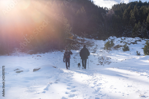 Two mens whit a dog go to the mountain in GRandvalira, Andorra