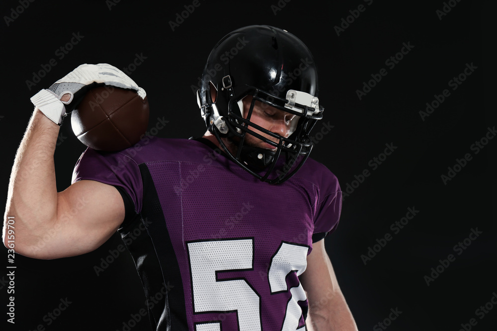 American football player with ball on dark background