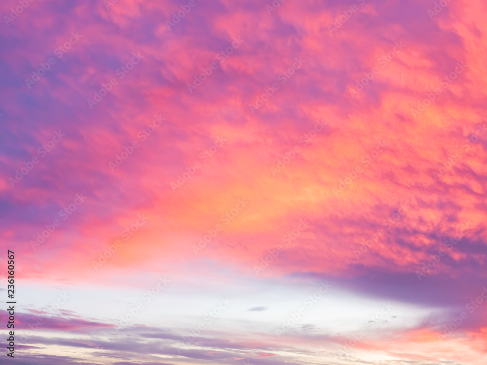 Fondo con nubes dramaticas de tormenta al atardecer, en colores magentas, rosados y anaranjados. 