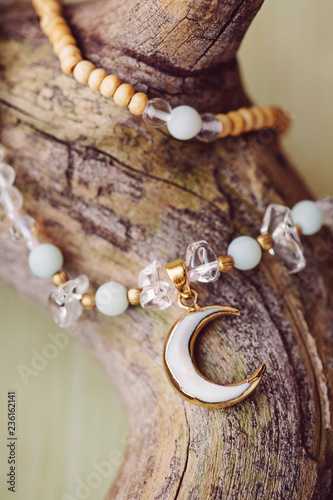 Moon pendant mineral stone beads necklace on wooden background