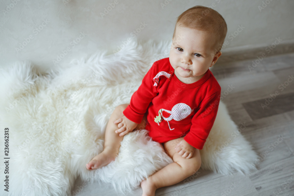 A little girl at the photo shoot, dressed in red coat.