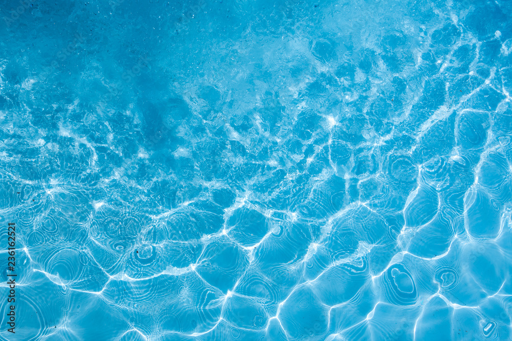 Background of rippled pattern of clean water in a blue swimming pool.