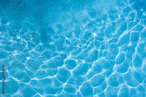 Background of rippled pattern of clean water in a blue swimming pool. © warongdech