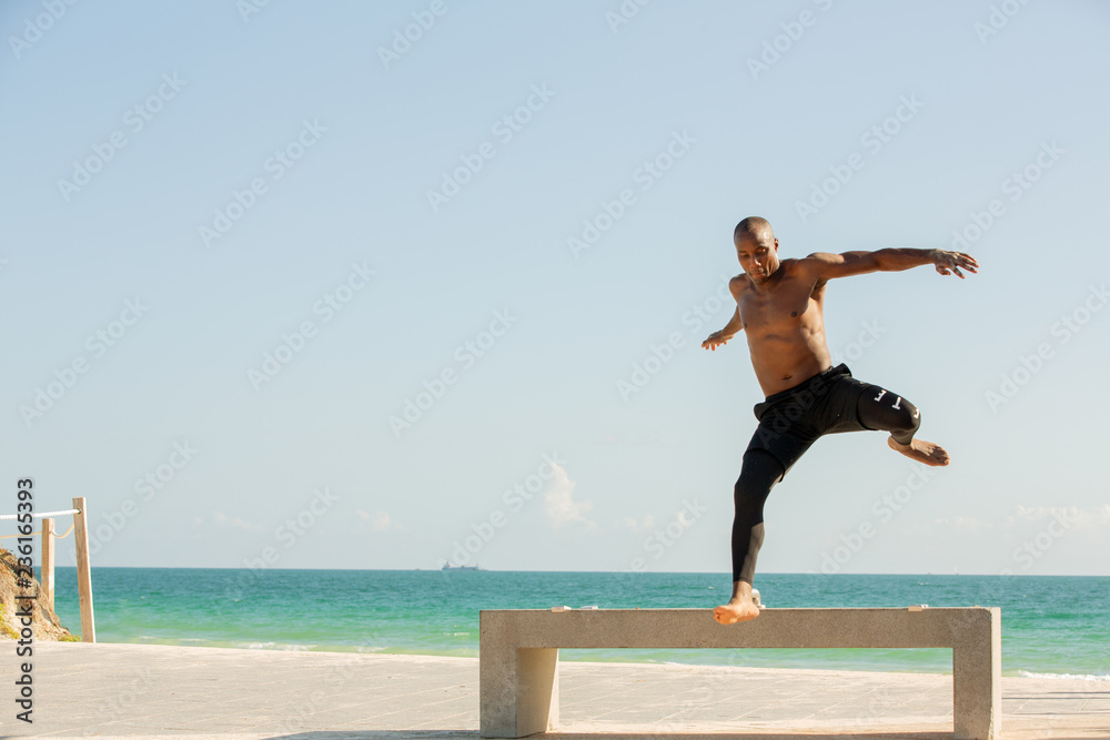 Man jumping a bench at the beach Man jumping a bench at the beach