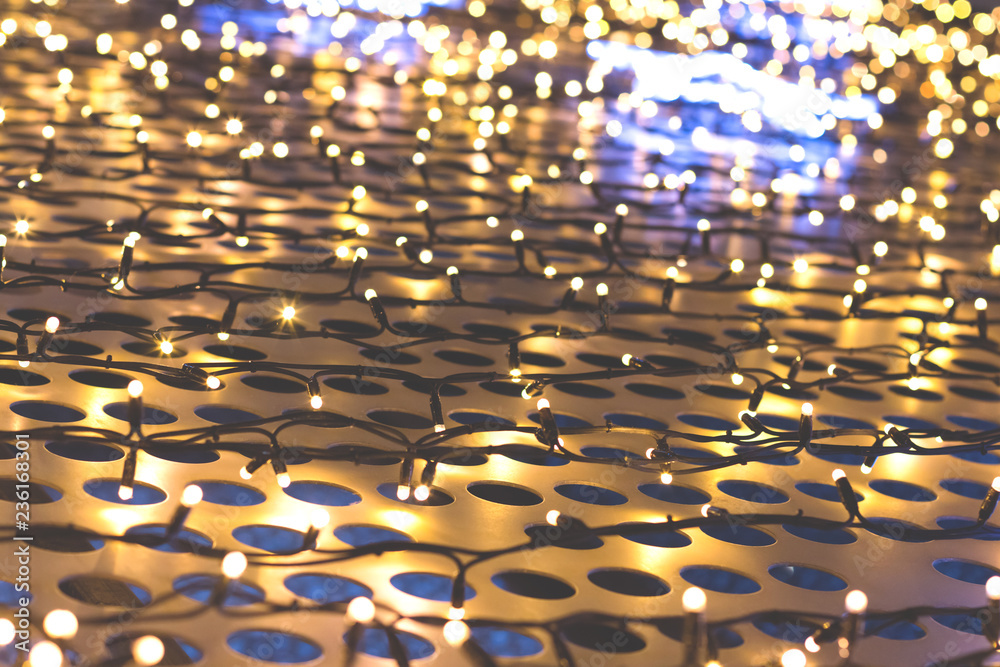 Christmas lights of garland on a metal grill with circles, cream color Christmas lights of garland on a metal grill with circles, cream color
