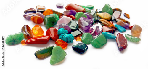 Slika na platnu Spilling assorted natural bright coloured semi precious gemstones and gems on wh