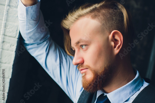 Portrait of blonde young man with uncommon appearance wears white t shirt.