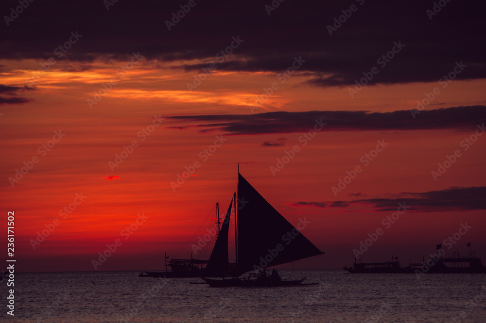 Dramatic colorful sea sunset with sailboat. Summer time. Travel to Philippines. Luxury tropical vacation. Boracay paradise island. Nature background. Seascape view. Tourism concept. Water transport