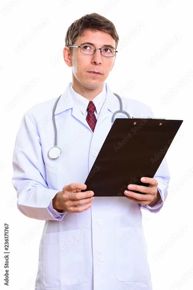 Studio shot of man doctor holding clipboard while thinking Studio shot of man doctor holding clipboard while thinking